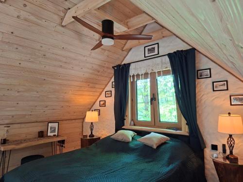 a bedroom with a bed and a ceiling fan at Woodland House 2 in Berezka