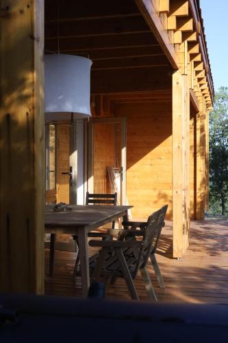 - une table et des chaises en bois sur la terrasse couverte d'une cabine dans l'établissement SUNCHILL luxury treehouse, à Saint-Antonin