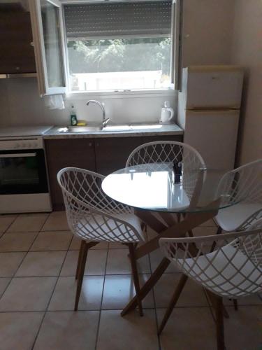 a kitchen with a table and chairs and a sink at Spiridoula's Apartments Corfu in Perama