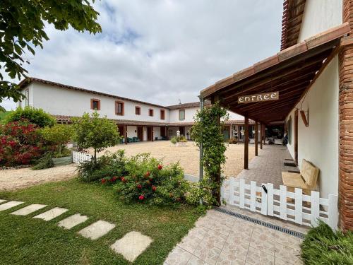 a building with a white fence next to a courtyard at residence la Salamandre kamers in Rabastens