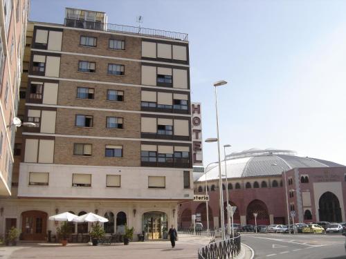 a building with a person walking in front of it at Hotel Aranda in Aranda de Duero