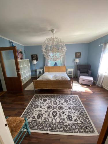 a living room with a bed and a chandelier at Vindsvåning Höga Kusten in Kramfors
