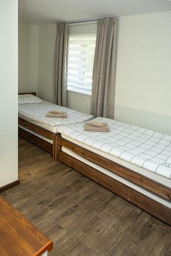 two twin beds in a room with a window at Guest House in Ventspils
