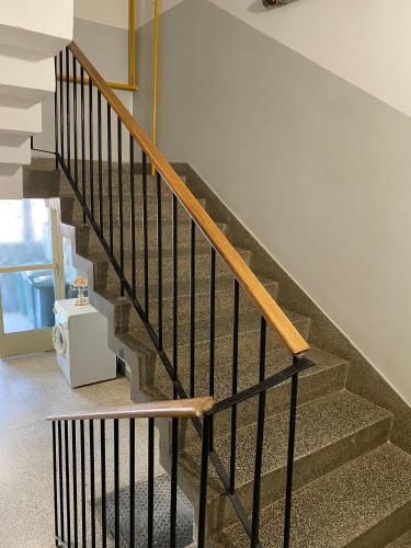 a staircase in a house with a wooden hand rail at Apartman 'City View' Popovača in Popovača