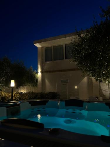 a swimming pool in front of a house at night at La Depèndance Luxury Rooms in Francavilla al Mare