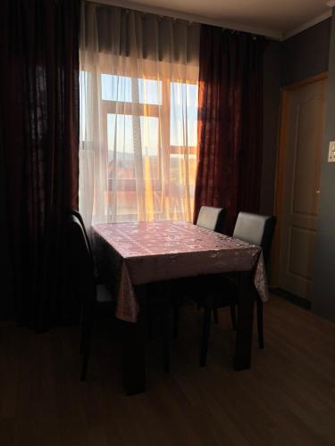 a dining room table with chairs and a window at Apartmani Radovanovic in Soko Banja