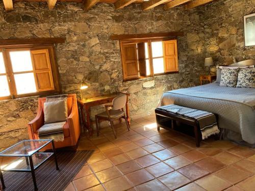 a bedroom with a bed and a table and a chair at Hotel Amor y Paz in Real de Catorce