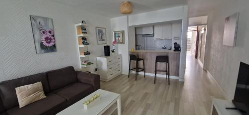 a living room with a couch and a table and a kitchen at Apartamento Las Americas in Arona
