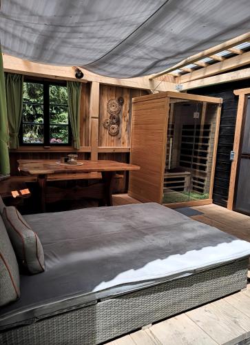 a bedroom with a bed and a table and windows at Almhuette Auszeit in Donnersbachwald