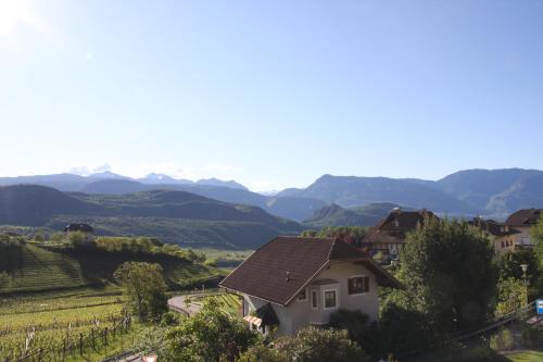 a house in a vineyard with mountains in the background at Residence La Terrazza in Caldaro