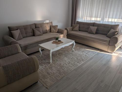 a living room with two couches and a coffee table at MB Apartment Ferizaj in Ferizaj
