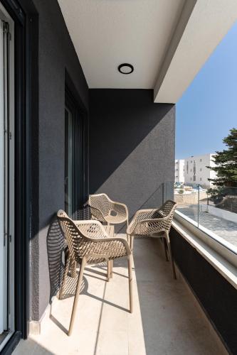 a group of chairs sitting on a balcony at Villa SHARK 2 with a pool in Novalja
