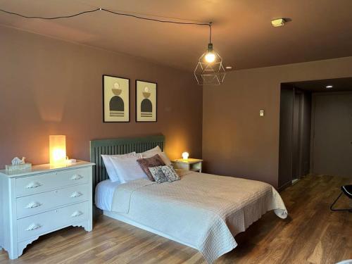 a bedroom with a bed and a dresser with two lamps at Auberge Les Sources in La Malbaie