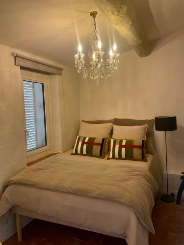 - une chambre avec un grand lit et un lustre dans l'établissement Appartement Saint-Tropez Centre L'Annexe, à Saint-Tropez