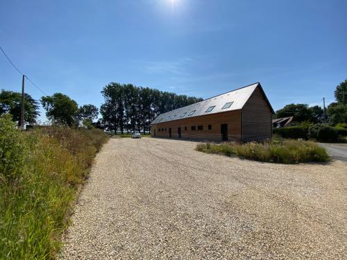 a barn sitting on the side of a gravel road at La grange du clos in Angiens