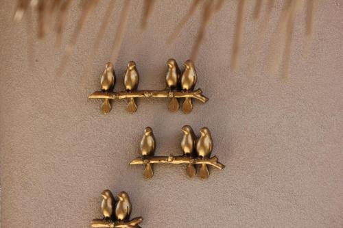 a group of gold birds sitting on a fork at Roby's Boutique Rooms - Luxury B&B in Catania