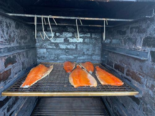 a grill with some food cooking on it at Sea view Holmestrand sauna and hot tube appartment in Holmestrand