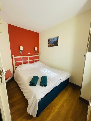 une chambre avec un lit avec deux oreillers verts dessus dans l'établissement Appartement saint Raphaël - cap esterel- 5 couchages- parking couvert, à Saint-Raphaël