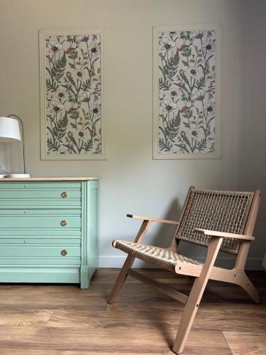 a room with a dresser and a chair next to a dresser at Auberge Les Sources in La Malbaie