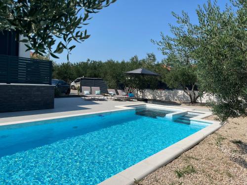 a swimming pool in the backyard of a house at Kuća za odmor Laura in Biograd na Moru