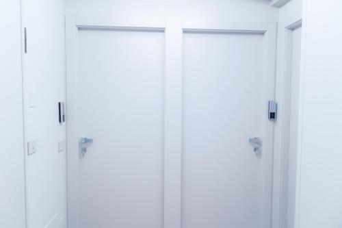 a row of white doors in a room at Virginia Madre Luxury Rooms in San Benedetto del Tronto