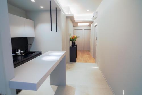 a kitchen with white countertops and a hallway at Virginia Madre Luxury Rooms in San Benedetto del Tronto