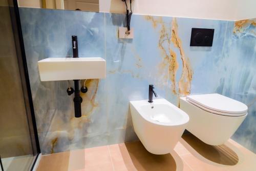 a bathroom with a toilet and a sink at Virginia Madre Luxury Rooms in San Benedetto del Tronto