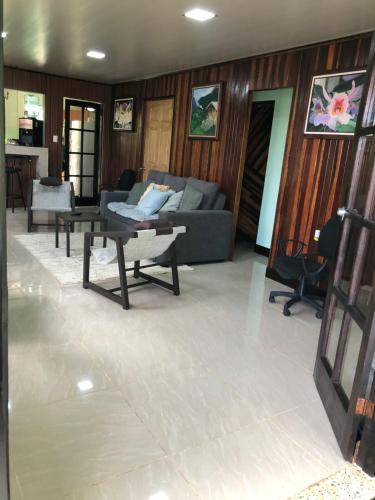 a living room with a couch and a table at Casita Canto del Bosque Monteverde in Tilarán
