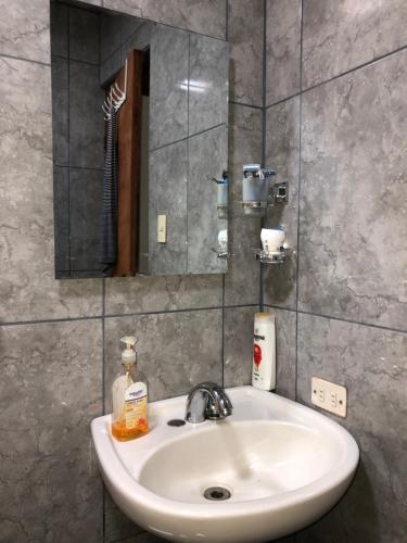 a white sink in a bathroom with a mirror at Casita Canto del Bosque Monteverde in Tilarán