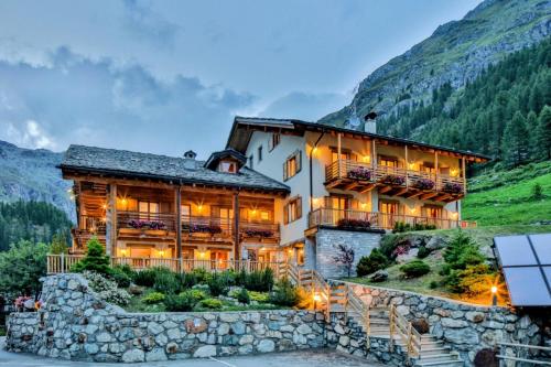 a large building with a stone wall at Ellex Eco Hotel in Gressoney-la-Trinité