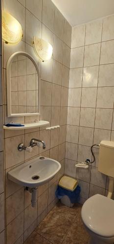 a bathroom with a sink and a toilet at Pokoje U Wandy in Łeba