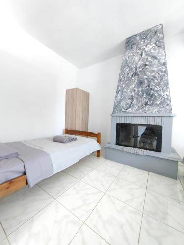 a bedroom with a bed and a fireplace at Anthos Rooms Vrasna in Nea Vrasna