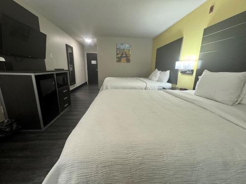 a hotel room with two beds and a flat screen tv at Wingate by Wyndham Biloxi - Ocean Springs in Biloxi