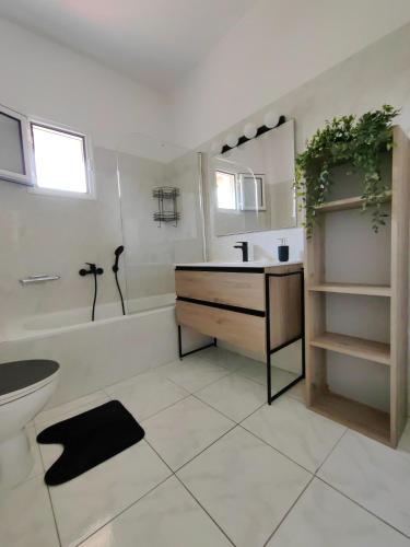 a bathroom with a sink and a tub and a toilet at Anthos Rooms Vrasna in Nea Vrasna