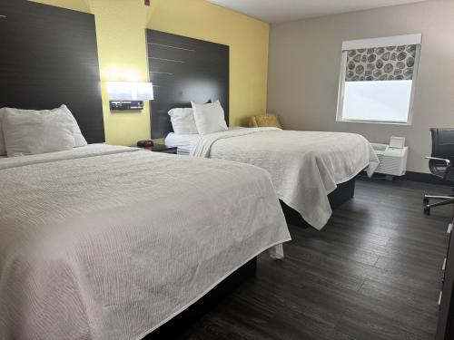 a hotel room with two beds and a window at Wingate by Wyndham Biloxi - Ocean Springs in Biloxi