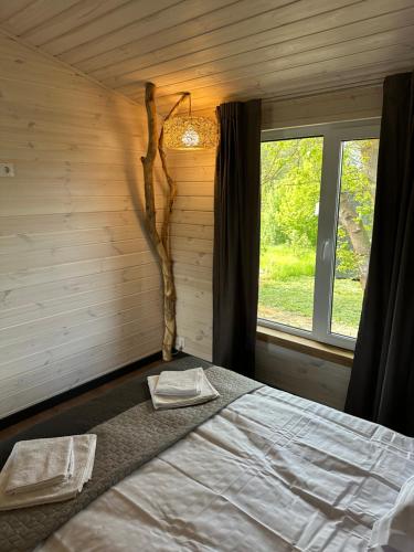a bedroom with a bed and a tree branch next to a window at Відпочинковий Еко комплекс "Затишна садиба" in Luchin