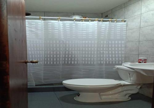 a bathroom with a toilet and a shower and a sink at El Barco Colonial in Quito
