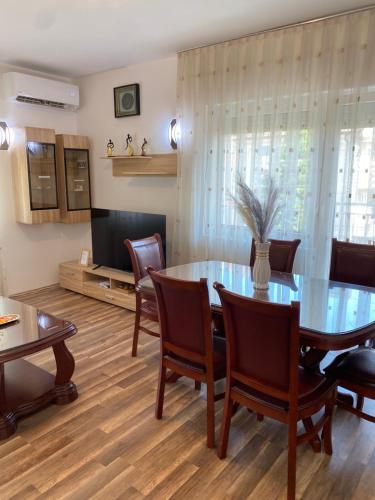 ein Esszimmer mit Tisch und Stühlen und einem Fernseher in der Unterkunft Kuzmanovski Apartments in Bitola