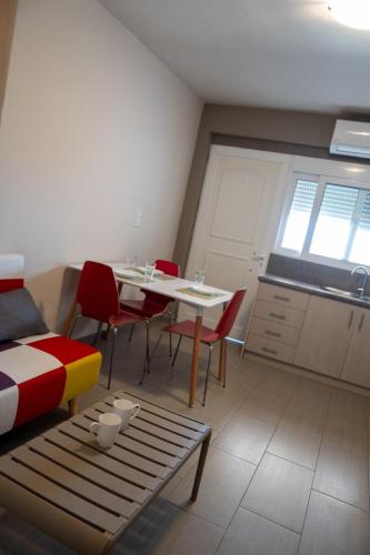 a room with a table and chairs and a kitchen at TSABAS BEACH SIDE APARTMENTS ΤΣΑΜΠΑΣ ΠΑΡΑΛΙΑΚΑ Διαμερίσματα 4 in Kyllini