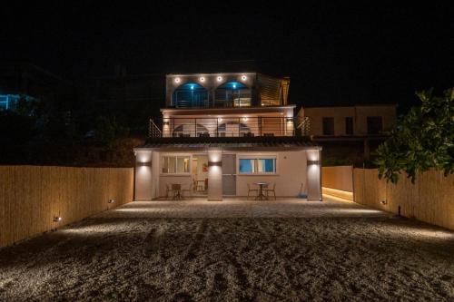 a large house with lights on top of it at night at TSABAS BEACH SIDE APARTMENTS ΤΣΑΜΠΑΣ ΠΑΡΑΛΙΑΚΑ Διαμερίσματα 4 in Kyllini
