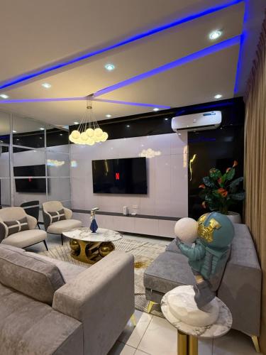 un salon avec un canapé et une télévision à écran plat dans l'établissement KT And Sons Ltd, à Lekki