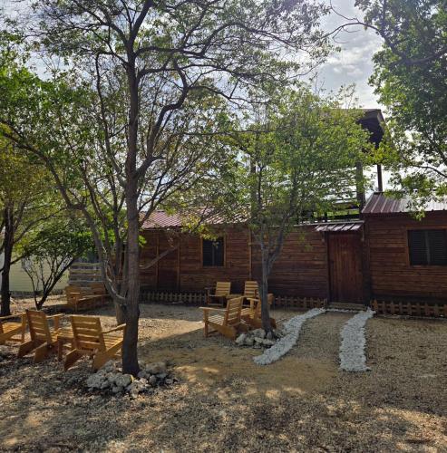 a group of benches in front of a log cabin at La Casita De La Cueva in Cabo Rojo