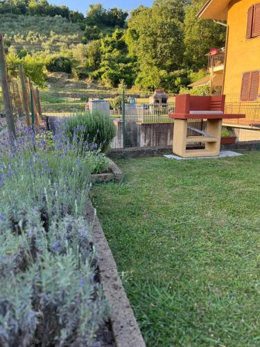 a bench sitting in a yard with purple flowers at Casa Vacanze La Cicala in Pontremoli