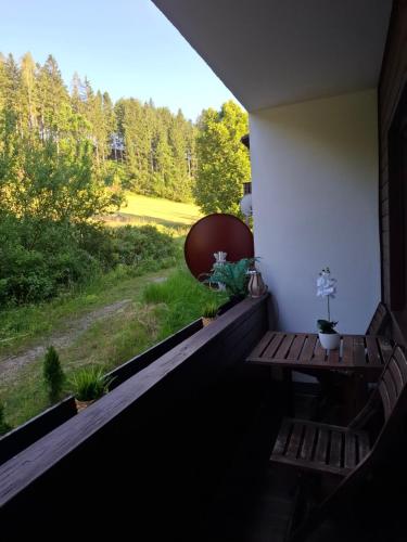 a porch with a bench and a view of a field at Ferienwohnung am Bischofsberg in Edlbach