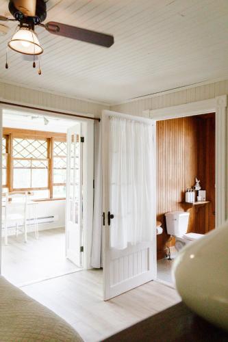 a bedroom with a door open to a bathroom at Auberge Les Sources in La Malbaie