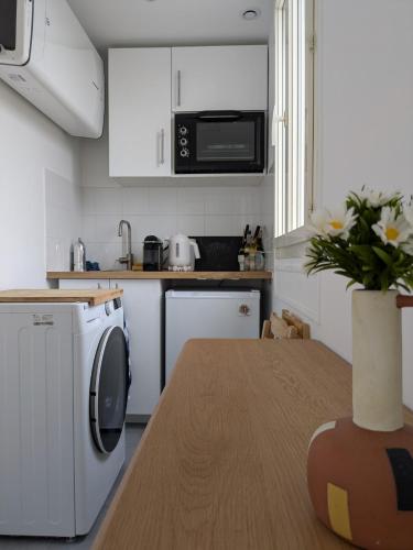 une cuisine avec une machine à laver et une table dans l'établissement Eiffel Pearl, à Paris