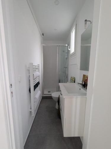 une salle de bain blanche avec un lavabo et des toilettes dans l'établissement Eiffel Pearl, à Paris