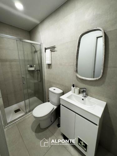 a bathroom with a toilet and a sink and a mirror at Casa das Nogueiras By ALPONTE in Mazedo