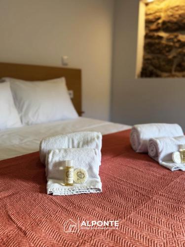 a bed with two towels and two candles on it at Casa das Nogueiras By ALPONTE in Mazedo