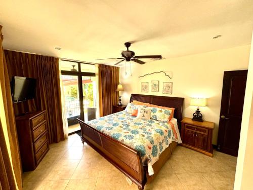 Un dormitorio con una cama y un ventilador de techo. en Costa Rican Jaco Haven, en Jacó